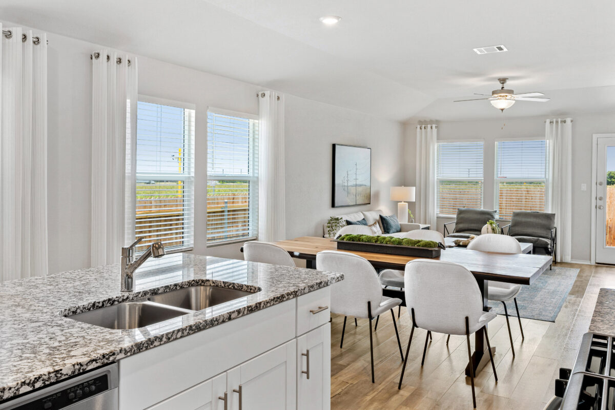 Photo of staged family room with view of fenced backyard.