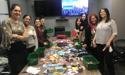 A group of women in conference room assembling relief kits.
