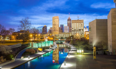 Night time view of canal walk with city skyline in the background